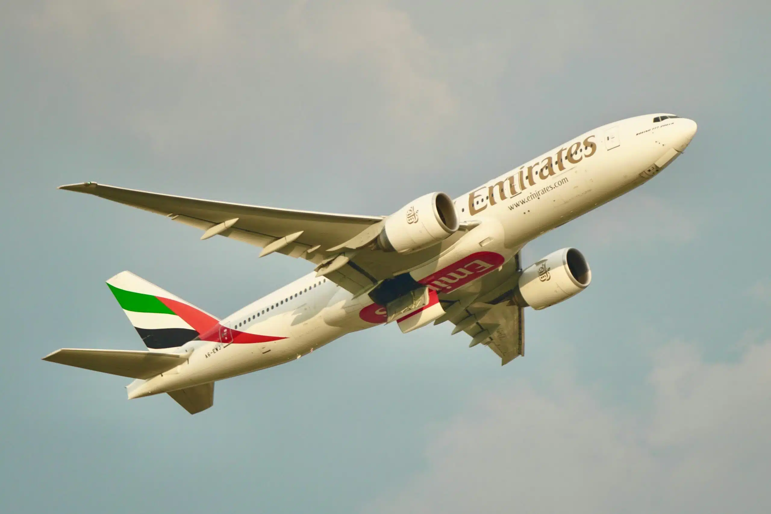 An Emirates plane flying in a clear sky, showcasing dynamic flight and travel inspiration.