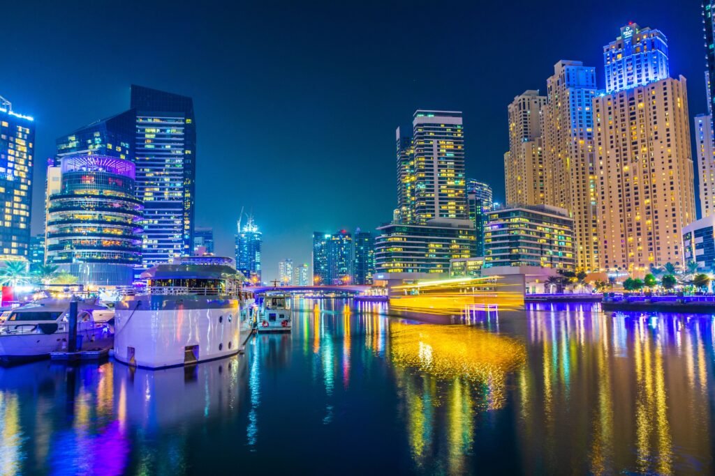 إطلالة ليلية نابضة بالحياة لمرسى دبي (دبي مارينا) تظهر فيها ناطحات السحاب المضيئة واليخوت وهي تنعكس على سطح الماء